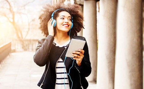Woman with tablet listening with headphones