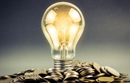 Lit-up lightbulb on a mound of change