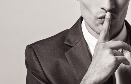 Man holding finger up to lips